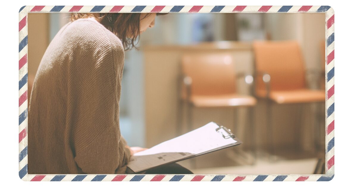英語の問診票を前に不安を感じる妊婦のイメージ